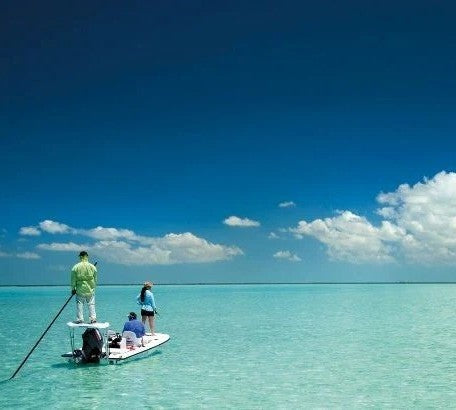 Guide and angler on boat polling the flats looking for bonefish