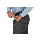 Person wearing gray Simms MEN's Waypoints Pant with a visible brand logo on a white background