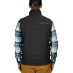 Person wearing a black Simms MEN's Fall Run Insulated Vest w/CRO Logo with 'Simms' branding, plaid shirt, and brown pants on a white background
