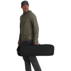 Man holding a black Simms Tailwind Rod & Reel Vault case on a white background