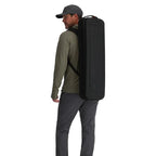 Man wearing a large black backpack on a white background