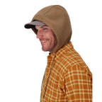 Man wearing a brown hooded jacket over a plaid shirt on a white background