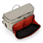 Open beige Simms Headwaters Sling Pack with red interior on a white background