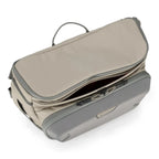 Sling pack with beige exterior and gray interior on a white background. 