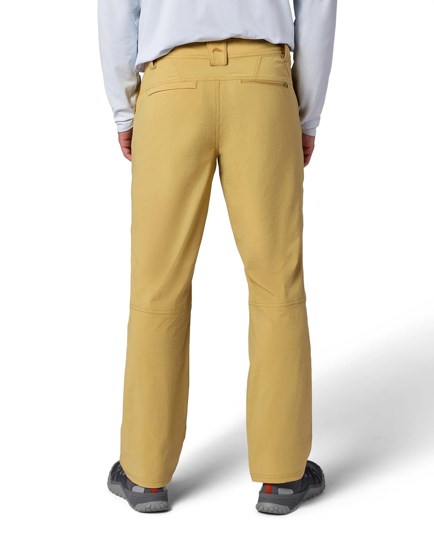 Person wearing Simms Guide Beige pants with a brand logo on a white background