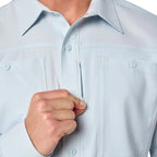 Light blue shirt with a hand adjusting the collar on a white background