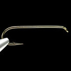 A single gold-colored Daiichi 1720 3X-Long Streamer Hook against a black background.