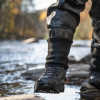 Person wearing Simms M's Flyweight® Wading Boot - Vibram walking through a shallow stream with autumn foliage in the background.