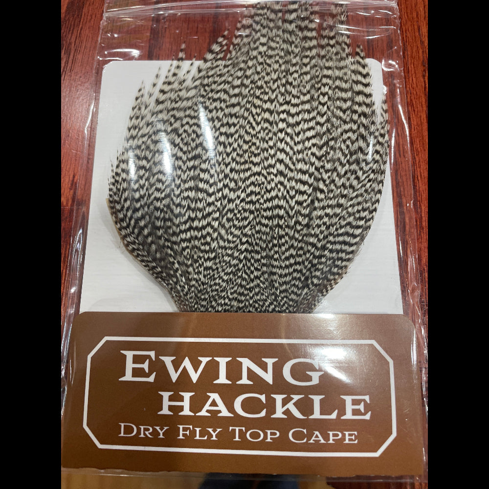 Packaged Ewing Hackle dry fly top cape on a wooden surface