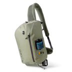 A green Orvis PRO Waterproof Sling 14L fishing backpack with a camouflage pattern on the shoulder strap, featuring multiple zippered compartments and a patented docking station.