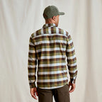 Man wearing a plaid Orvis MEN's Flat Creek Tech Flannel Shirt and cap from behind on a plain background