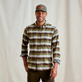 Man wearing a plaid Orvis MEN's Flat Creek Tech Flannel Shirt and cap against a plain background