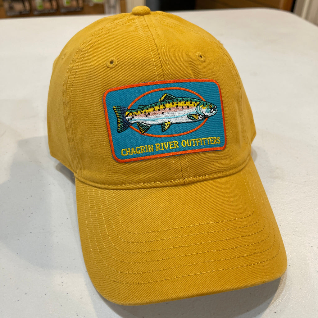 Yellow cap with a fish logo patch on a white surface
