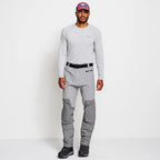 Angler wearing a pair of Orvis men's PRO LT wading pants in gray color with neoprene booties and a belt, designed for waist-high wading.