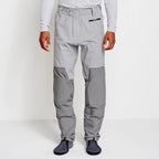 Angler wearing a pair of Orvis men's PRO LT wading pants in gray color with neoprene booties and a belt, designed for waist-high wading.