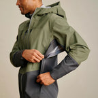Person wearing a green and gray Orvis MEN's PRO Fishing Jacket with a neutral background
