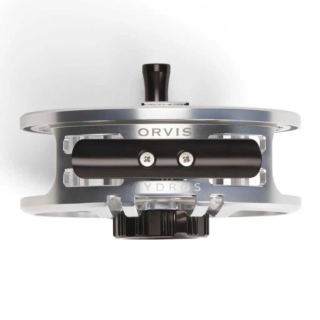 A close-up top profile of an Orvis Hydros metallic silver fly fishing reel with black handle and knob details, set against a clean white background.