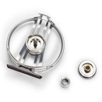 A stainless steel fly tying or fishing component set on a white background, featuring a circular metal frame, a central spool, a small ring, and a separate circular piece with a brass-colored center.