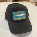 Black cap with a colorful fish logo on a white surface