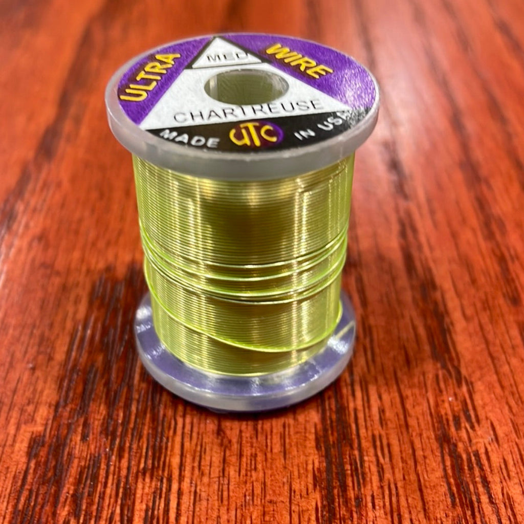 Spool of chartreuse Wapsi Ultra Wire UTC on a wooden surface
