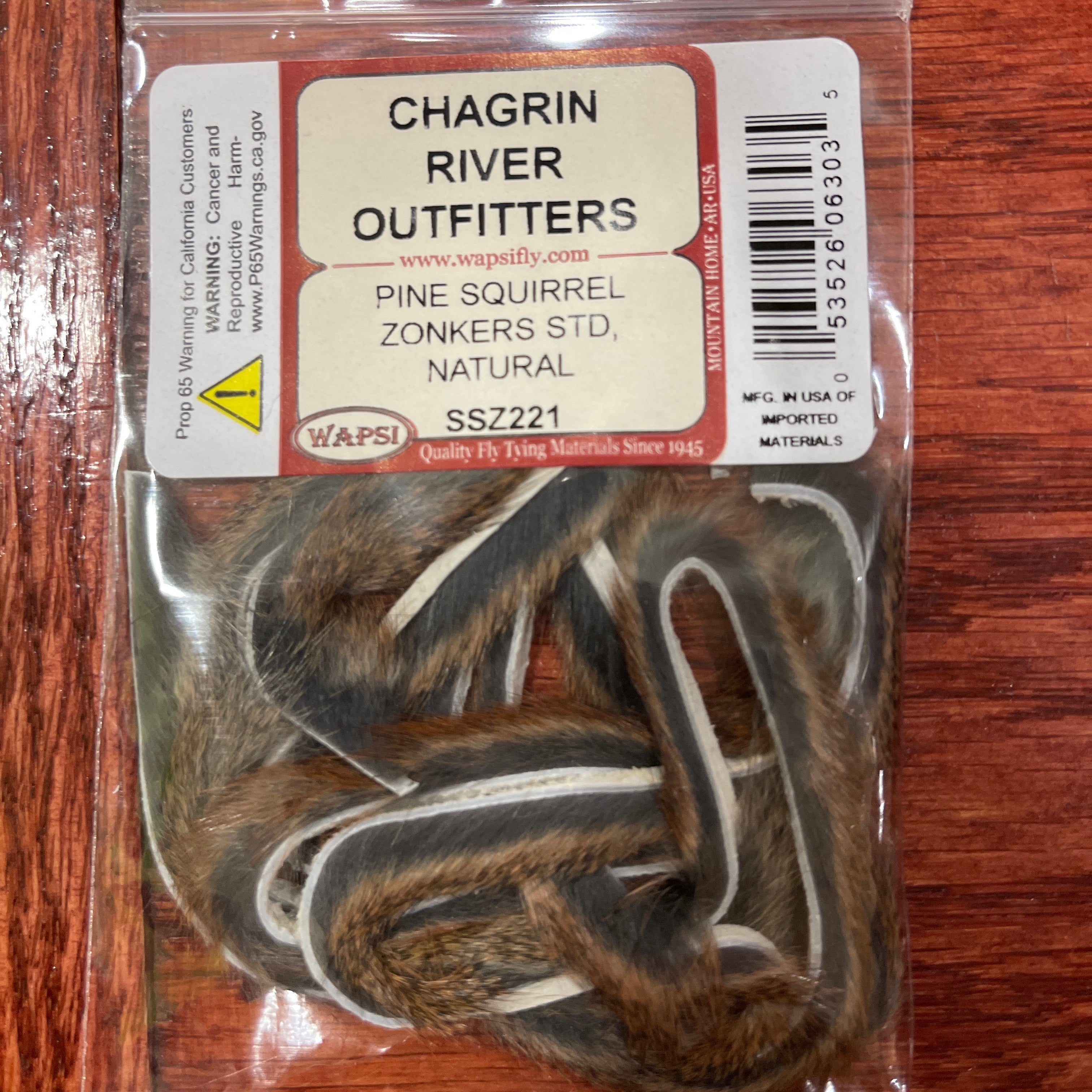 Packaged pine squirrels on a wooden surface with Chagrin River Outfitters label.