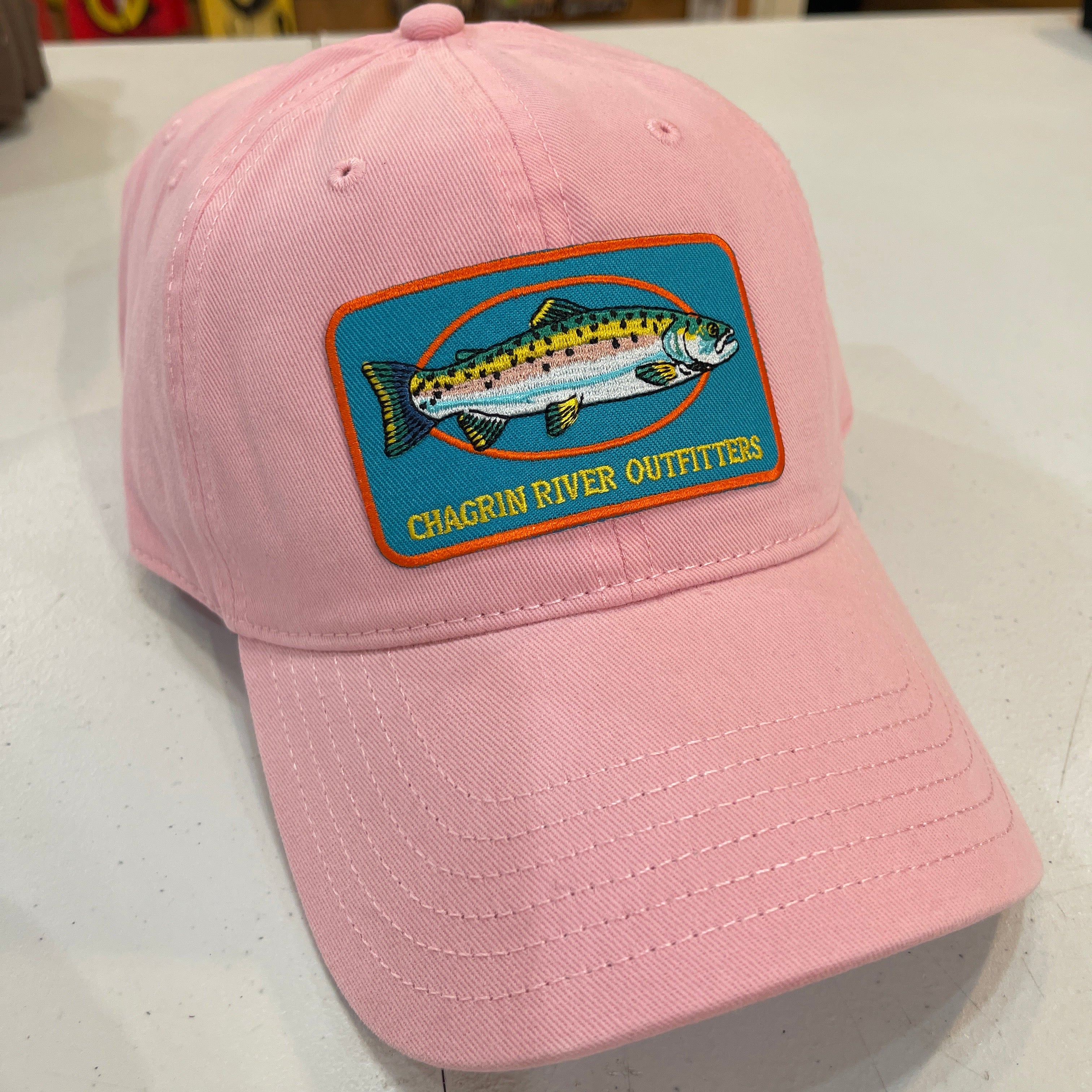 Pink cap with Chagrin River Outfitters patch featuring a fish on a white surface.