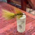 Fishing fly with a tag on a wooden surface
