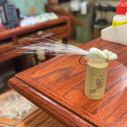 Fly fishing lure on a wooden surface with a store setting in the background