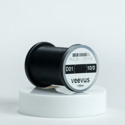 Spool of black veevus fly-tying thread on a white background