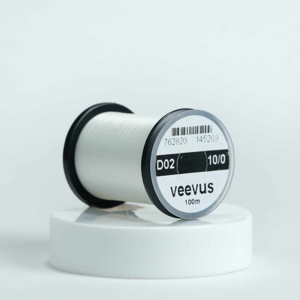 Spool of white veevus fly-tying thread on a white background