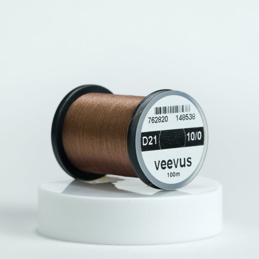 Spool of brown veevus fly-tying thread on a white background