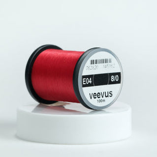 Red spool of Veevus Thread Polyester 8/0 with 'veevus' branding on a white background