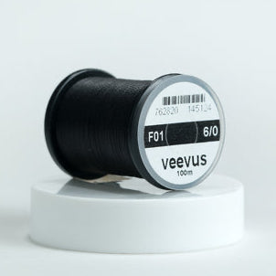 Spool of black Veevus Thread Polyester 6/0 labeled 'veevus' on a white background