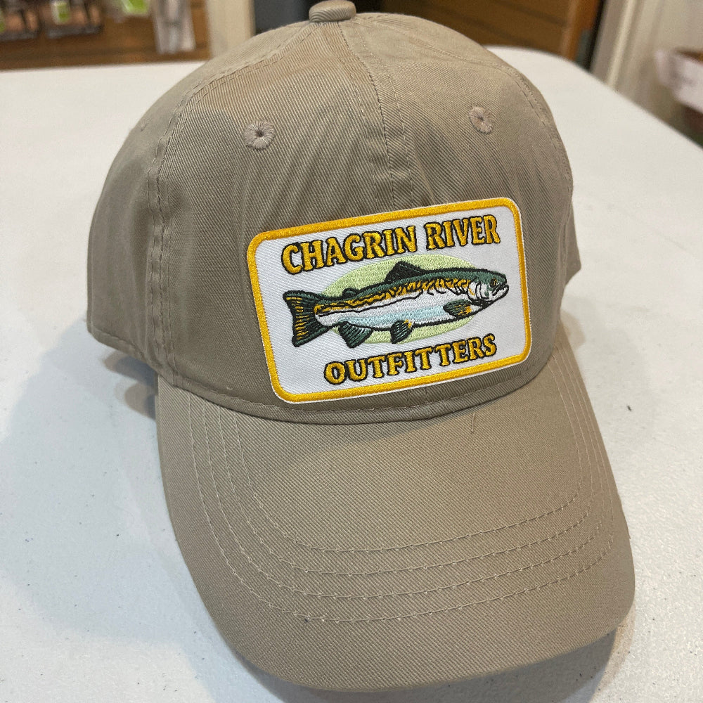 Beige cap with a fishing-themed patch on a white surface