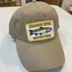 Beige cap with a fishing-themed patch on a white surface