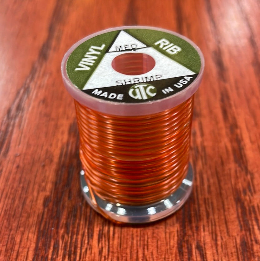 Spool of shrimp Wapsi UTC Vinyl Rib with a label on a wooden surface