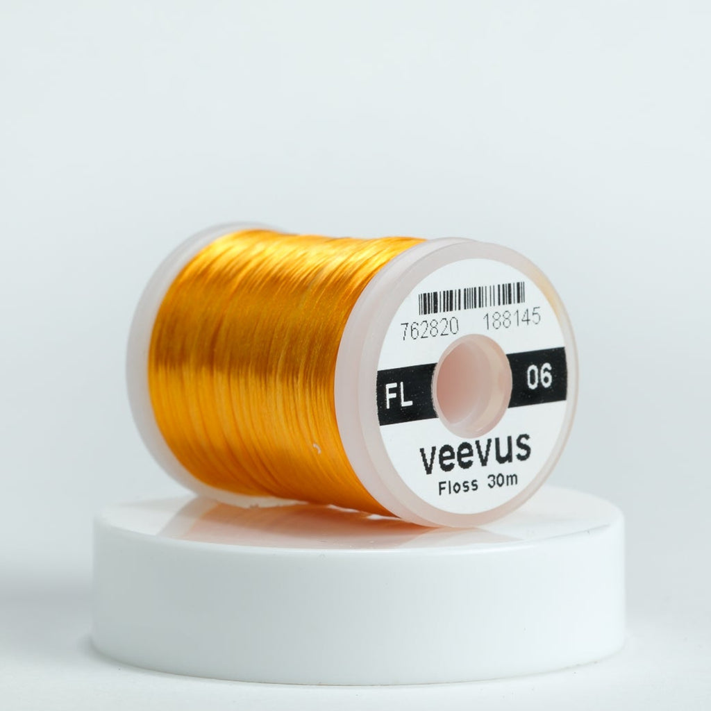 Spool of orange Veevus floss on a white background