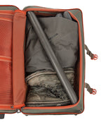 Open Green Fishpond Stormshadow Medium Rolling Duffel with orange straps on a white background with orange interior, gray boot, and gray garment inside.