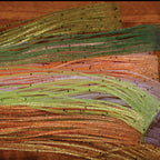 Close-up of green and brown Hareline Loco Legs on a wooden surface