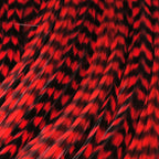 Red and black Hareline Half Grizzly Saddle on a textured background