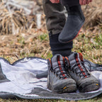Person wearing black boots with red accents on aSimms Taco Wader Bag w/CRO Logo.
