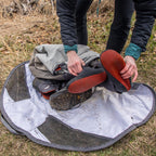 Person cleaning shoes on a Simms Taco Wader Bag w/CRO Logo outdoors