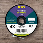 Spool of RIO Fluoroflex Strong Tippet Material with the text '4X' indicating the line size, '7LB' indicating the test weight, and 'FRESHWATER' marked as the type of tippet. The spool is labeled with additional details such as '0.