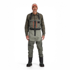 Man wearing a plaid shirt, gray Simms MEN's Freestone Z (Zipper) Stockingfoot Waders, and a beanie on a white background