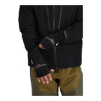 Person wearing a black jacket and Simms WINDSTOPPER® Half-Finger Fishing Glove with a visible brand logo on a white background