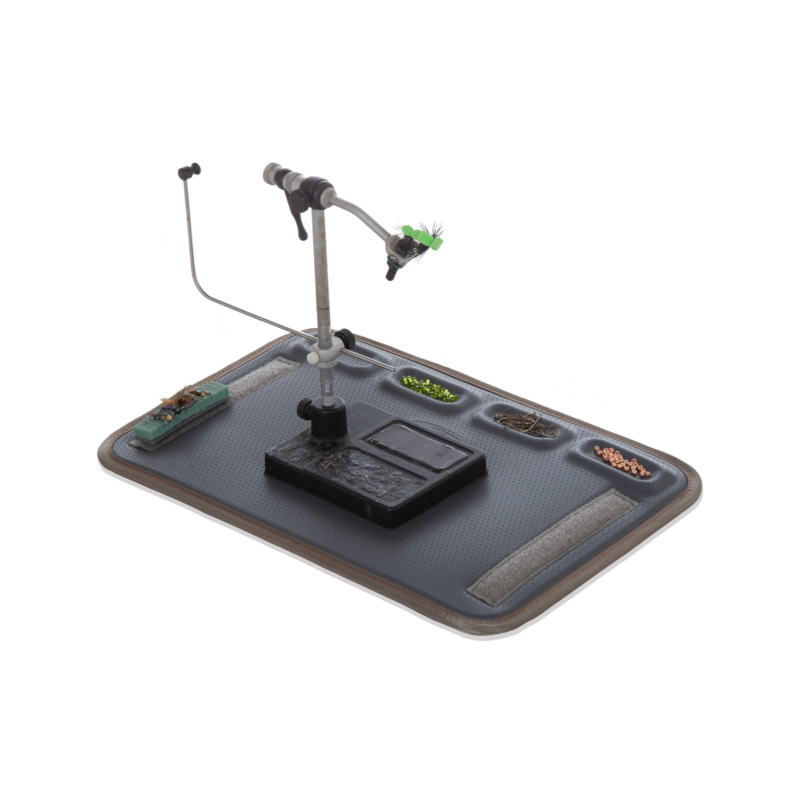 Fly tying station with a mat, vise, and accessories on a white background