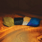 Four swatches of different colored Hareline Dyed Deer Body Hair on a wooden surface