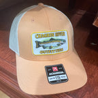A tan and white trucker hat with a 'Chagrin River Outfitters' fish patch on the front and a 'Richardson 115' size label on the side, photographed on a dark wood floor.