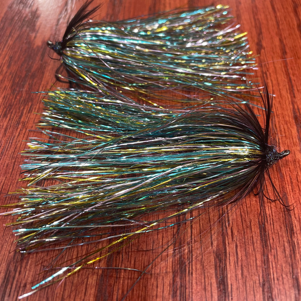 Fishing fly with metallic fibers on a wooden surface
