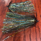 Fishing fly with metallic fibers on a wooden surface